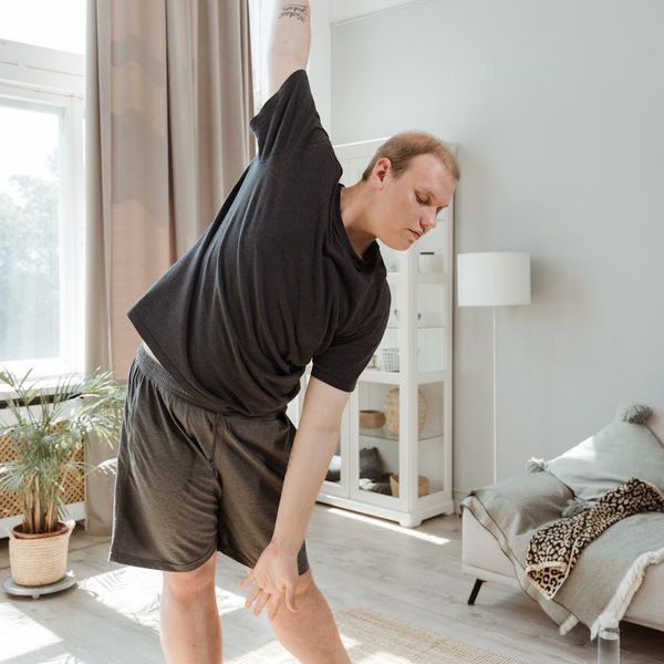 Man stretching in a calm, modern environment, symbolizing flexibility and peace.